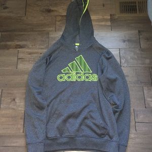 A grey hoodie with adidas in neon green.
